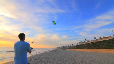 OTS Man Flying Kite on Beach at Sunset Stock Footage 1561734