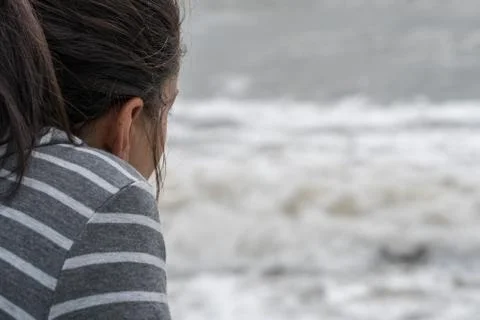 OTS over the shoulder point of view perspective of a young woman at the beach Stock Photos