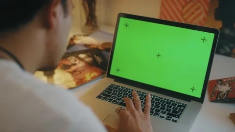 OTS Young male at desk checking emails on macbook green screen at night Video stock 73861536