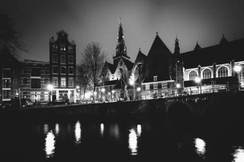 The Oude Church and a canal at night, in Amsterdam, The Netherlands. Stock Photos