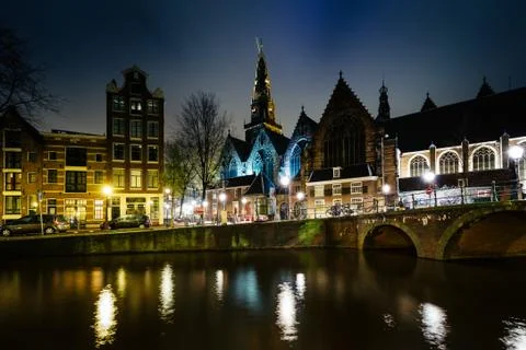 The Oude Church and a canal at night, in Amsterdam, The Netherlands. Stock Photos