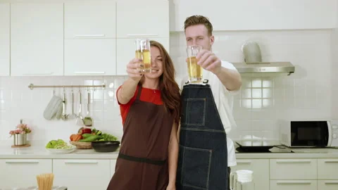 Ouples are helping each other in cooking and drinking juice, Stock Footage 155419107