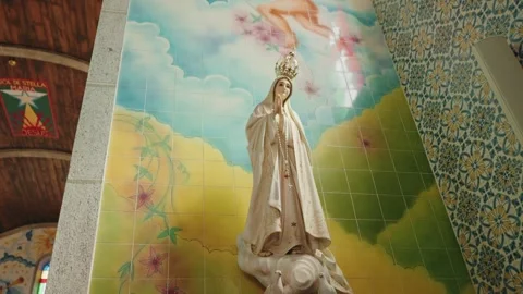 Our Lady of Fatima statue against painted tile mural in Portuguese church Stock Footage 337913253