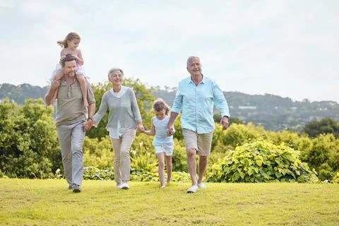 Our most basic instinct is for family. a family walking together in a park. Stock Photos