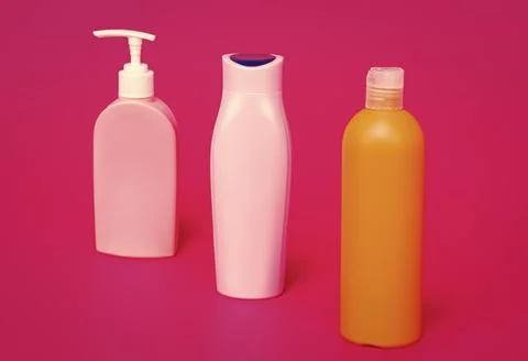 Our packaging solutions. Toiletry bottles pink background. Refillable bottles in Stock Photos