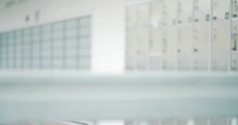 Out of focus background inside post office of p.o. boxes for mail security Stock Footage 96247312