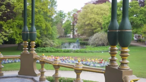 Out of focus background plate of gazebo in city park with tulips and fountain Stock-Footage 89781816