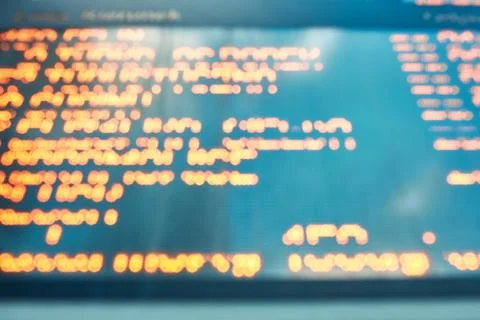 Out of focus blurred display screen with orange digital characters and letter Stock Photos