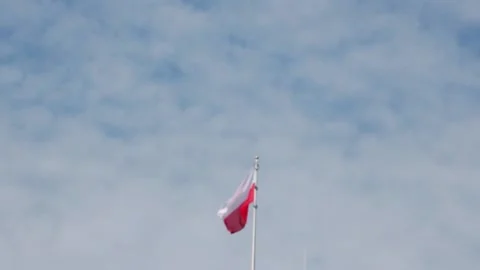 Out of focus, blurry background, the flag of Poland develops in the wind against 스톡 동영상 159793213