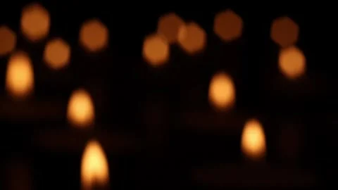 Out-of-focus candle flames extinguished by airflow in dark scene Stock Footage 323691958