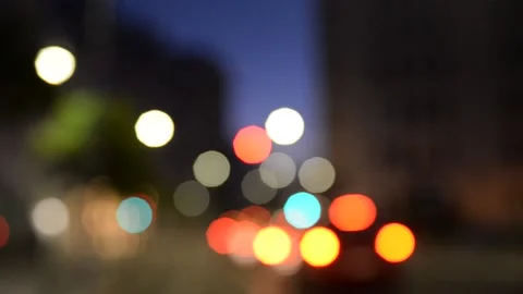 Out of focus cars leaving as traffic lights go green Stock Footage