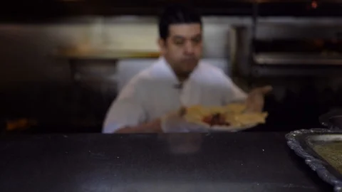Out of focus chef puts a plate of hummus with pita bread on a shelf ready Stock Footage 101124092