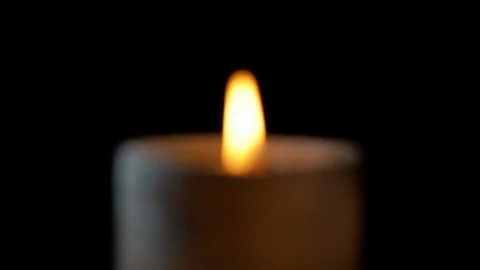 Out of focus dark candle burning close-up with black background Stock Footage 126061030