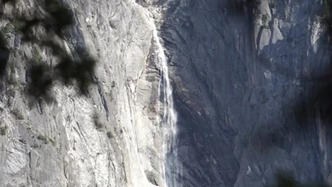 Out of focus to in focus: small waterfall with leaves in foreground in Yosemite Stockbeeldmateriaal 241194067