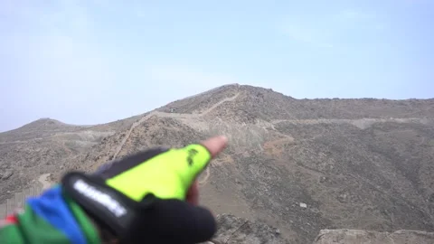 An out of focus hand pointing towards the route to follow on a trek Vidéo 145148019