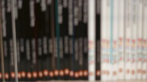 Out of focus horizontal view of blue and white book spines on a library shelf Stock Photos