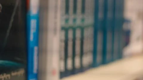 Out of focus horizontal view of blue and white book spines on a library shelf Stock Photos