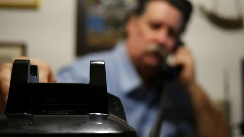 Out of focus man dials old black dial telephone Stock Footage 105445052
