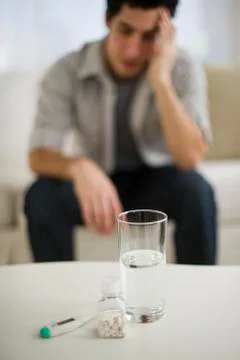 Out-of-focus man taking painkillers Stock Photos
