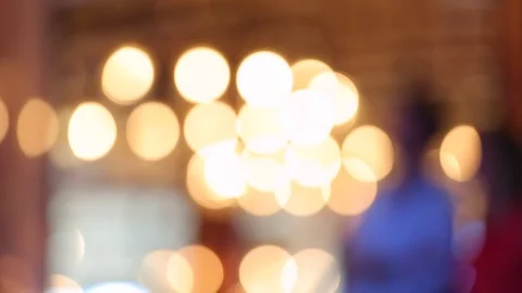 Out of focus people walk in front of light bokeh B Stock Footage 107346643
