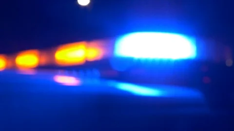Out of focus real, red and blue police cruiser lights flashing at night. Video stock 99518081