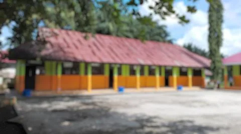 Out of focus, a rustic school building featuring faded colors and aged roof.. Fotos de archivo