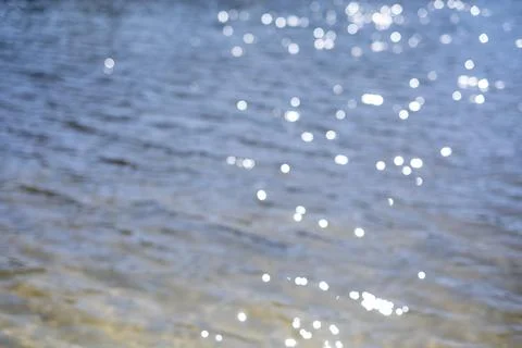 Out of Focus Shimmering Sunlight Reflections on Blue Water Fotos de archivo
