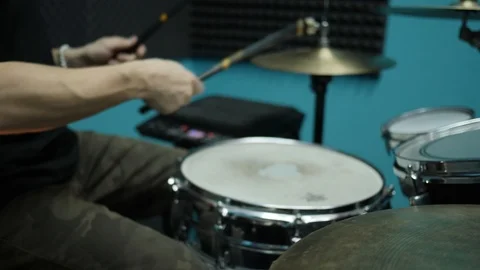 Out of focus shot of drummer playing on a drum kit. Musician rehearse in a Stock Footage 90284186