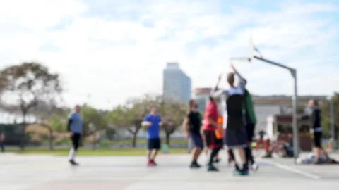 Out of focus shot of men playing a basketball game on an open air court Vídeo Stock 132648087