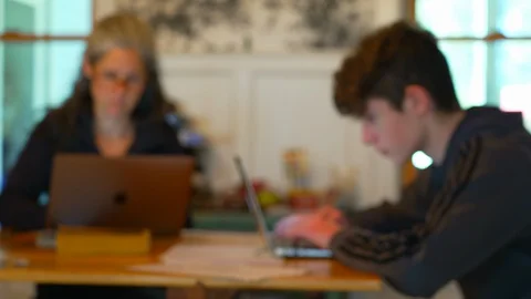 Out of focus shot of parent working with child at home Stock Footage 129640042