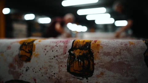 Out of focus shot of workers cutting out fabric Stock Footage 135269685