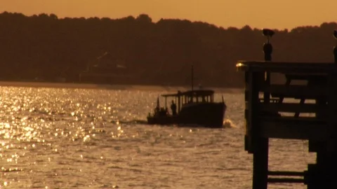 Out of focus small boat returning to port at sunset Stock Footage 117249421
