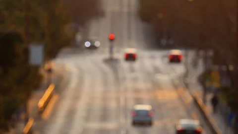 Out of focus small city intersection seen from high up. Cars arriving to a tr Stock Footage 128986669