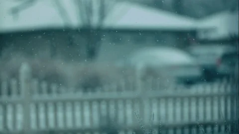 Out of Focus Snow Falling in Slow Motion Against White Fence Stock Footage 73339662