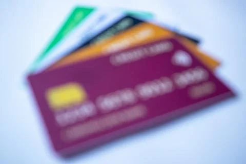Out-of-focus stack of colorful credit cards featuring purple, orange, dark .. Stock Photos