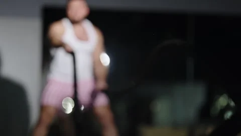 Out-of-focus video frames show an athlete driving intense battle rope training 库存影片 329820494