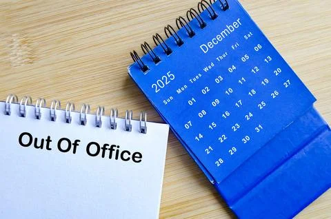Out of office text on white notepad with blue December calendar. Christmas .. Stock Photos