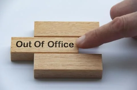 Out of office text on wooden blocks with hand pushing it. Getaway or on a v.. Stock Photos