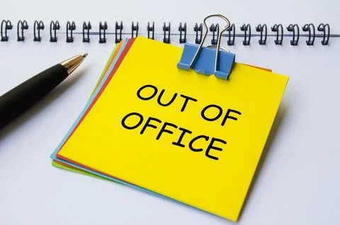 Out of office text on yellow notepad with white notebook background. Getawa.. Stock Photos