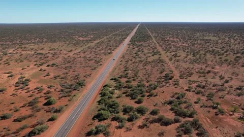 Outback Australia highway road in flat dry red desert landscape aerial footage Stock Footage 157348560
