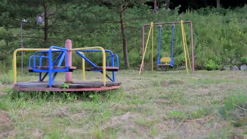 Outdated carousel and swing. They swing alone, without children. Life without Video stock 170395028