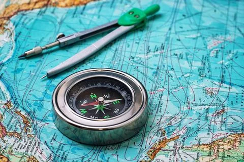 Outdated compass sailor on a topographic map Stock Photos