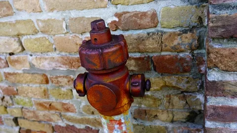 Outdated fire hydrant with red rusty top and greyish support 库存影片 150750808