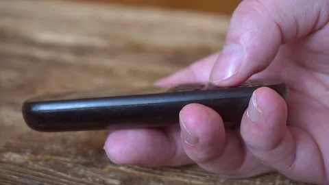 Outdated push button mobile phone in hand. 库存影片 105422694