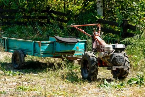 Outdated small tractor with a trailer. No people Stock Photos