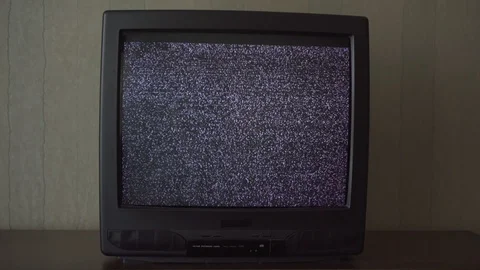 Outdated small TV with flashing screen located on table Stockbeeldmateriaal 120245929