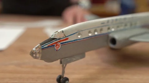 Outdated soviet aircraft model on brown wooden table Stock Footage 126895602