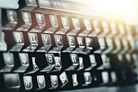 Outdated typewriter close-up. Broken keyboard with Russian letters. Stock Photos