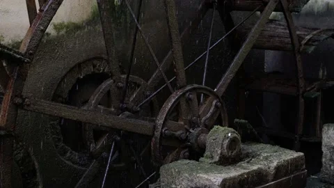 Outdated waterwheel with large rusty metal supports rotates 库存影片 149493436