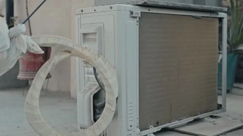 Outdoor AC Unit with Condenser Coil and Refrigerant Pipes 库存影片 337189913